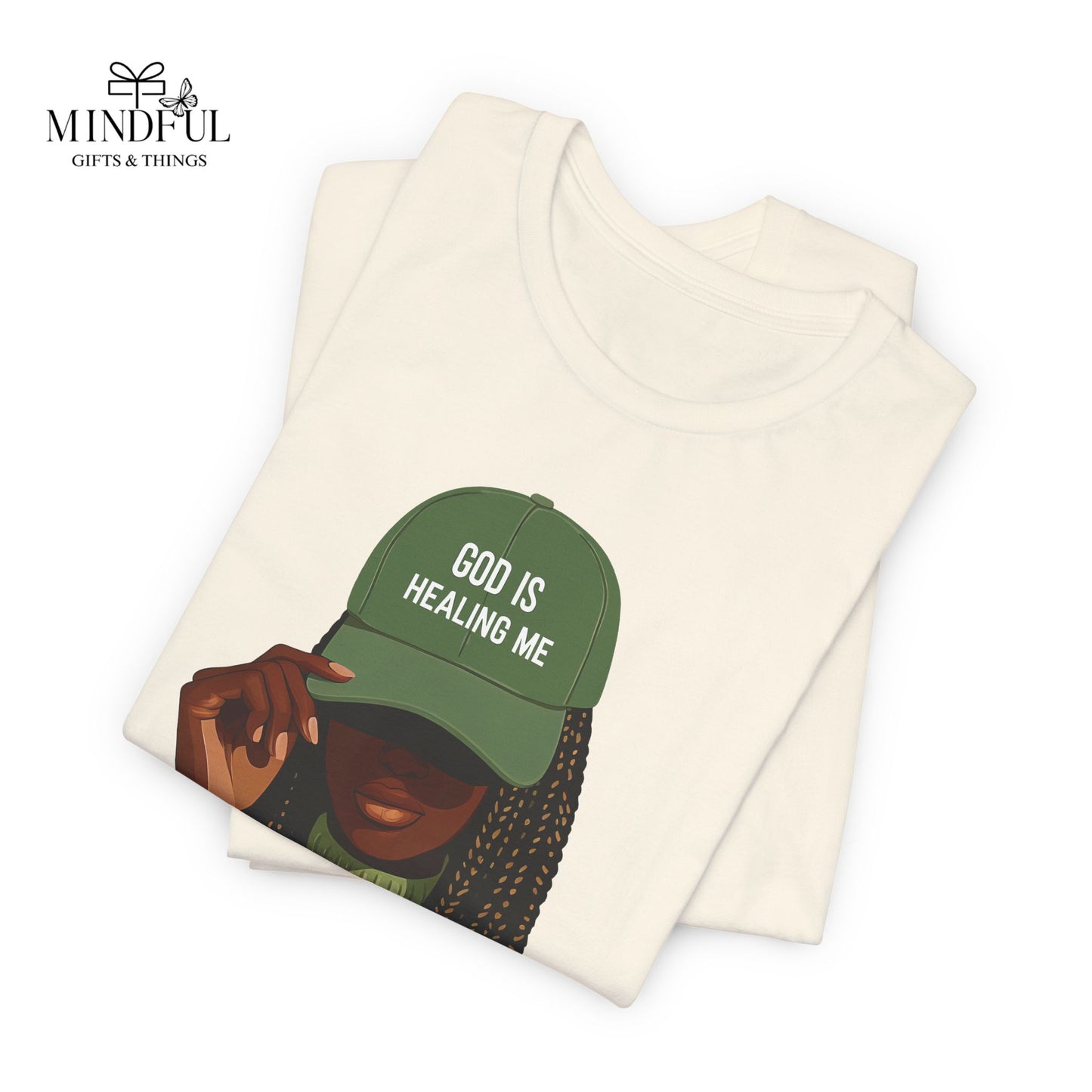God Is Healing Me Tee — Inspirational Faith T‑Shirt with Green Cap Graphic