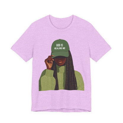 God Is Healing Me Tee — Inspirational Faith T‑Shirt with Green Cap Graphic