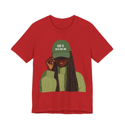 God Is Healing Me Tee — Inspirational Faith T‑Shirt with Green Cap Graphic