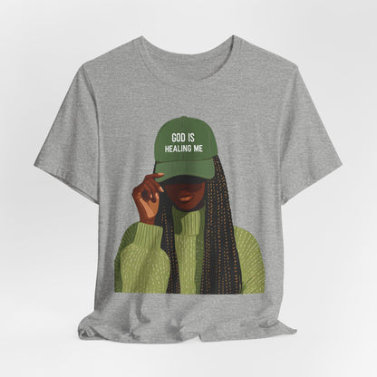 God Is Healing Me Tee — Inspirational Faith T‑Shirt with Green Cap Graphic