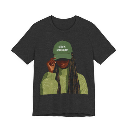 God Is Healing Me Tee — Inspirational Faith T‑Shirt with Green Cap Graphic