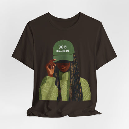 God Is Healing Me Tee — Inspirational Faith T‑Shirt with Green Cap Graphic