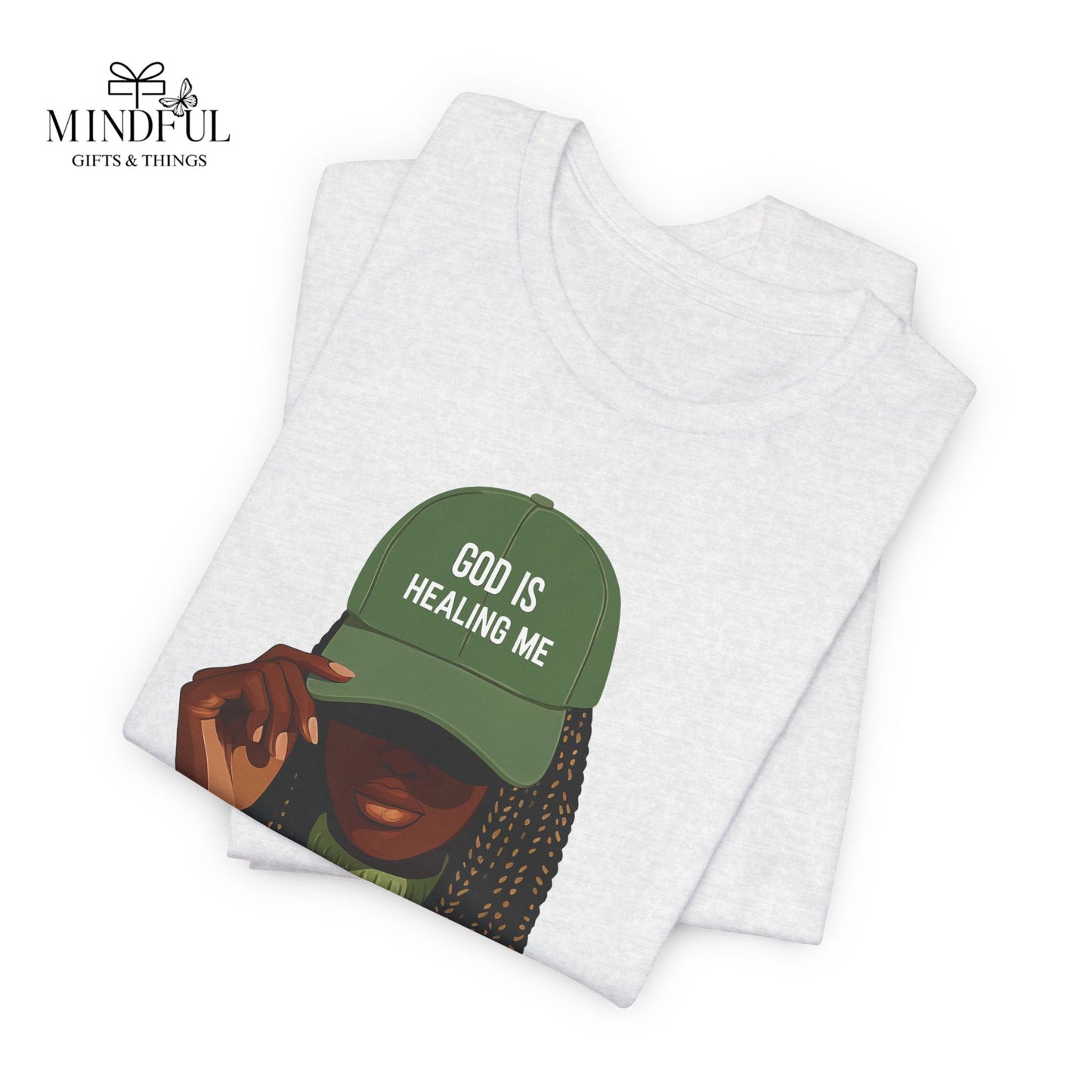 God Is Healing Me Tee — Inspirational Faith T‑Shirt with Green Cap Graphic