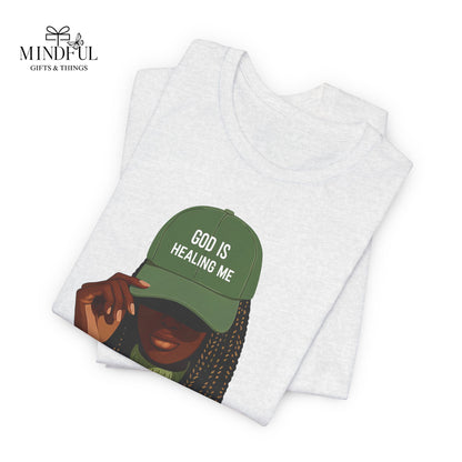 God Is Healing Me Tee — Inspirational Faith T‑Shirt with Green Cap Graphic