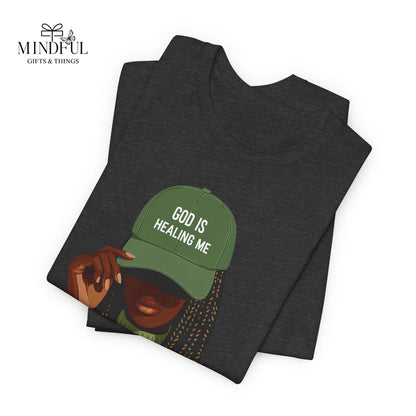 God Is Healing Me Tee — Inspirational Faith T‑Shirt with Green Cap Graphic