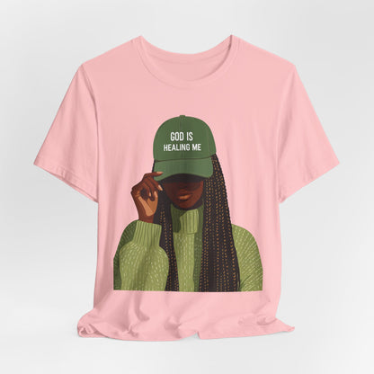 God Is Healing Me Tee — Inspirational Faith T‑Shirt with Green Cap Graphic