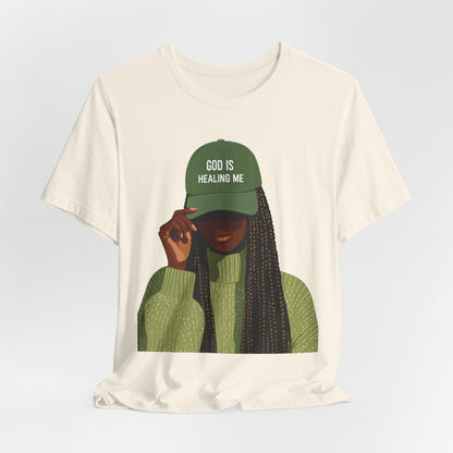 God Is Healing Me Tee — Inspirational Faith T‑Shirt with Green Cap Graphic