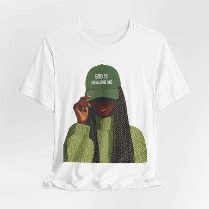 God Is Healing Me Tee — Inspirational Faith T‑Shirt with Green Cap Graphic